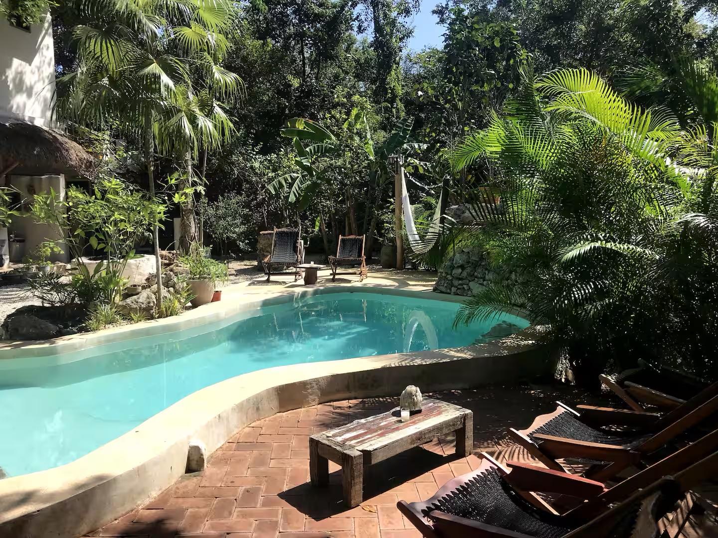 Private resort pool surrounded by lush tropical greenery